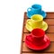 Colorful cups on wooden tabletop