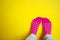 Colorful cute pink sock with white dot with women foot on yellow
