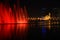 Colorful dancing fountain with mosque in the city at night with lively music