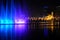 Colorful dancing fountain with mosque in the city at night with lively music