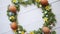 Colorful decorative Easter eggs wreath on white wooden table background
