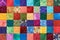 Colorful detail of quilt sewn from square pieces