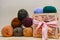 Colorful different textile yarn thread balls. Row of long wide folded wool on the depth box field. Wooden box with pink