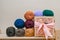Colorful different textile yarn thread balls. Row of long wide folded wool on the depth box field. Wooden box with pink