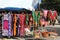 Colorful dresses and woven bags at an outdoor flea market