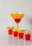 Colorful drink in a margarita glass, red and orange combination, four drinks in a shotglass