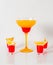 Colorful drink in a margarita glass, red and orange combination, four drinks in a shotglass