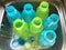 Colorful drinking plastic bottles are being washed in kitchen wash basin