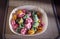 Colorful dumplings in a white plate on the table.