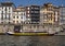 Colorful dwellings and the Porto Cruz tourboat along the Douro River in the Ribeira neighborhood of Porto, Portugal.