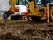 Colorful earth moving machines on muddy construction site