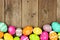 Colorful Easter Egg bottom border on a wood background