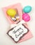 Colorful Easter Egg Table Setting with Silverware, Dyed eggs, Pink Napkin, Card on off white cloth