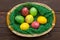 Colorful easter eggs in basket on wooden background. Eggs handmade new style of colouring . Pattern, easter concept