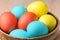 Colorful Easter eggs in brown pottery. Easter eggs are a symbol and a mandatory attribute of Easter