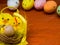 Colorful easter eggs with chickens nest on brown wooden table