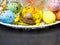 Colorful easter eggs with chickens nest on white plate