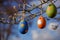 Colorful easter eggs hanging on tree branches on a sunny day with blue sky background. Selective focus. Concept of
