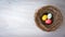 Colorful Easter eggs in rustic nest on wooden background. Flat L