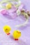 Colorful Easter frame - quail eggs, chickens and willow branch on a lilac background concrete