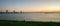 Colorful evening sky over distant cranes at the dutch shore