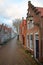 Colorful facades of historic houses along a paved street in Edam