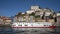 Colorful facades and a river tour boat in the neighborhood of Ribeira on the riverbank of the Douro in Porto, Portugal.