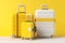 Colorful family suitcases for parents and child ready for vacation on bright yellow background