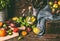 Colorful farm organic tomatoes with ingredients and cooking tools on dark rustic wooden kitchen table.