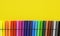 Colorful felt-tip pens on a yellow background.