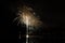 Colorful fireworks show with rockets bursting above the lake