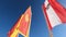 Colorful flags flutter on flagpoles. Close-up