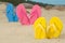 Colorful flip flops on white beach sand