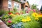 colorful flower beds beside brick tudor house