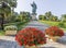 Colorful flowers with the imposing Colossus of San Carlo Borromeo, Arona, Italy in the background