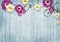 Colorful flowers over blue wooden background with copy space