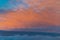 Colorful fluffy clouds outside an airplane at sunset