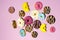 Colorful flying doughnuts on light pink background. Creative concept in minimal style
