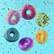 Colorful flying doughnuts with sprinkles on blue background.