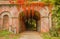 The colorful foliage of beech tree adorns a brick arch