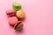 Colorful french macarons isolated on pink background. Top view