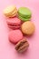 Colorful french macarons isolated on pink background. Top view