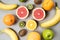 Colorful fresh fruit on Gray table. Orange, banana, apples, kiwi