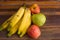 Colorful fresh summer fruits on brown wooden background, healthy organic food on table, detox vitamin nutrition for health care.