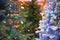 Colorful frosted white and evergreen artificial Christmas tree on display, warm LED micro fairy lights stunning illumination, tips