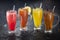 Colorful fruit juices in glasses with ice