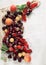 Colorful fruits and berries fresh from the market, decorated on white wood plate,