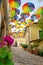 Colorful fun umbrellas hanging over the street in Szentendre with flowers