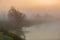 Colorful gentle dawn on the river. Beautiful morning in the fog