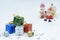 Colorful gift boxes pile with blurred Santa Claus doll and Christmas decorations on white background